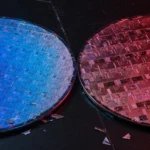 Two silicon wafers lit blue and red side by side, AI-generated illustration