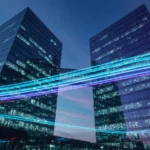 Two glass towers at dusk connected by light trails, AI-generated illustration