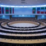Empty circular assembly hall with rows of desks, AI-generated illustration