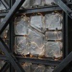 Translucent glass server modules embedded within a dark architectural lattice, connected by threads of amber light